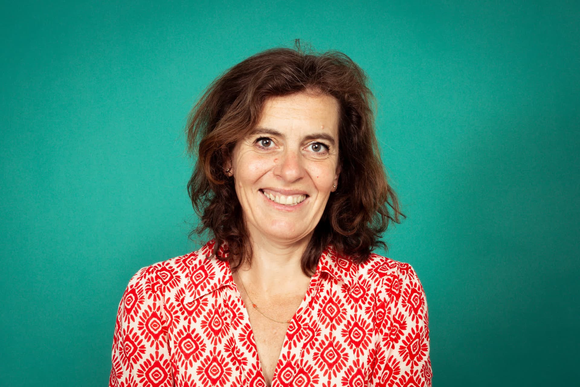 Emily Staphorst lachend voor een groene achtergrond